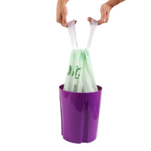 Compostable drawstring bag being used in trash bin