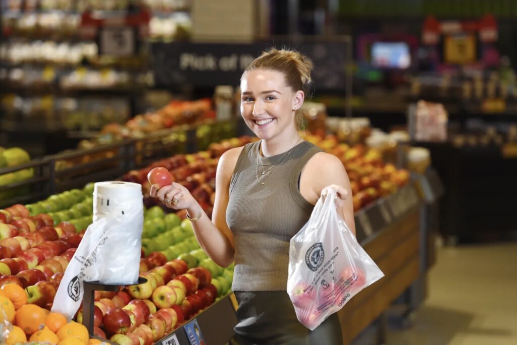 Custom Compostable Bags: Private Label & Branding Opportunities for Retailers 3 Retail customer using branded compostable shopping bag in supermarket
